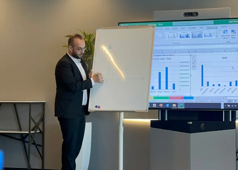 Majd explaining a data dashboard at a whiteboard